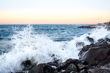 Sea waves in sunset with rocks and stones. Nature landscape.