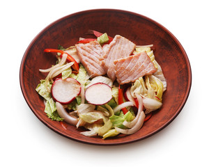 Bowl of original asian salad with salmon and vegetables isolated at white