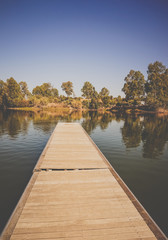 wooden pier on big lake surrounded by trees