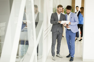 Two businessmen with a tablet in the office