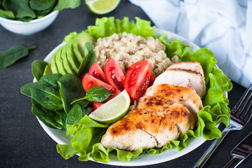 Fresh salad from quinoa, chicken breast, spinach, lettuce and tomatoes