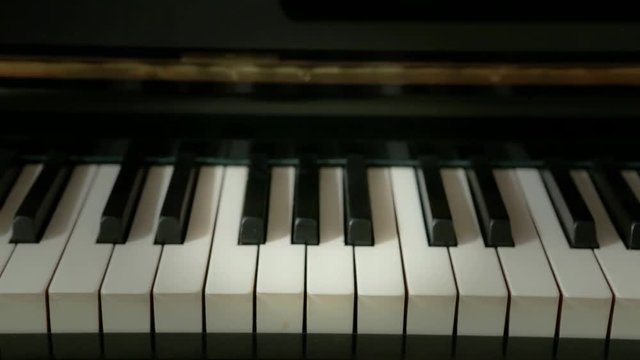 Closeup on piano keys. Camera travel from right to left. Straight from the front.