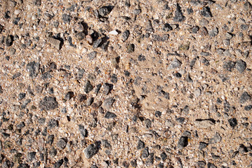 Close-up background texture stone granite fine sand in concrete black gray yellow shell color summer day vacation weekend