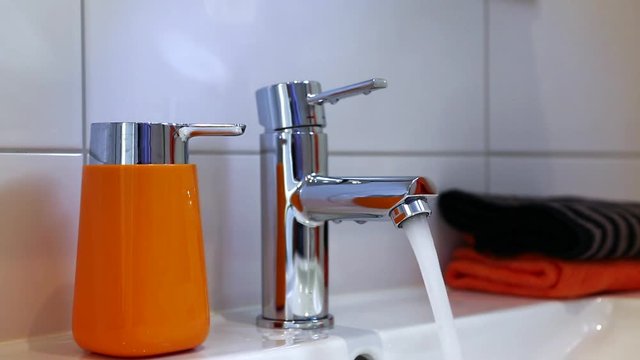 Water tap in modern bathroom. Water running. water are turned on and off.