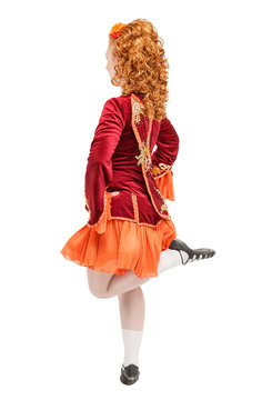 Beautiful woman in red dress for Irish dance jumping isolated. Back pose