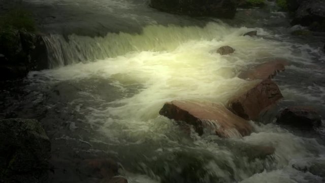 Dreamlike golden waterfall in stream.