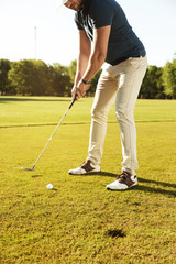 Fototapeta premium Male golfer about to tee off a golf ball