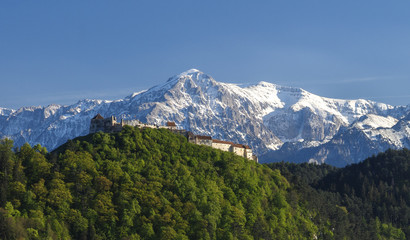 Rasnov Citadel, historic monument and landmark against high mountain in a sunset light.