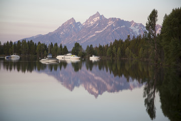 The peaks of the Grand Tetons across Jackson Lake marina in early morning light, Wyoming