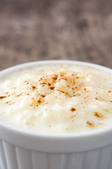 Arroz con leche. Rice pudding with cinnamon on wooden background
