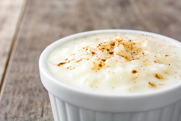 Arroz con leche. Rice pudding with cinnamon on wooden background
