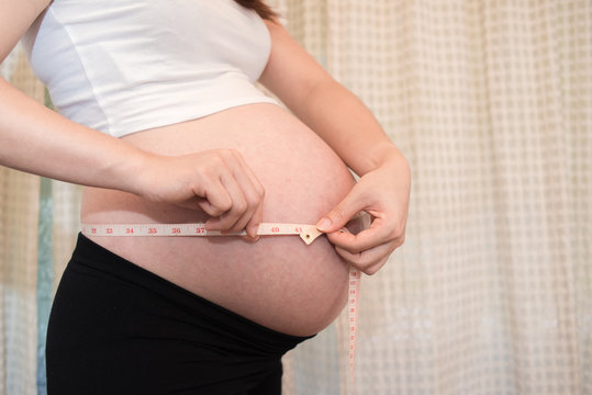 a pregnant woman measure Belly, baby coming soon on the world