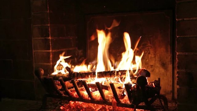 A cozy view of the burning logs in a home fireplace