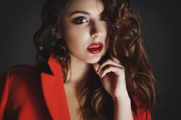 Beautiful young woman posing in studio over grey background. Fashion concept.