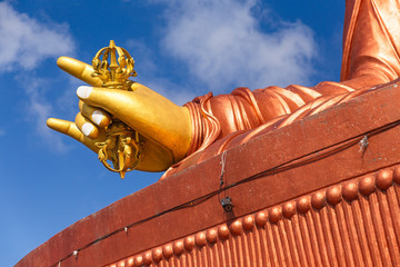 Close up at the right golden hand with mace of Guru Rinpoche statue, the patron saint of Sikkim in...