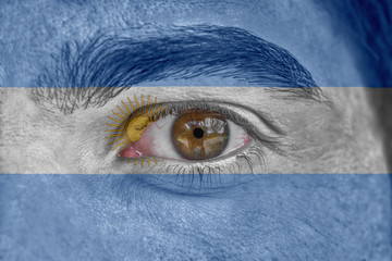 Human face and eye painted with flag of Argentina