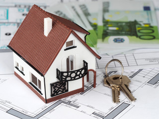 Toy house and keys on building plan