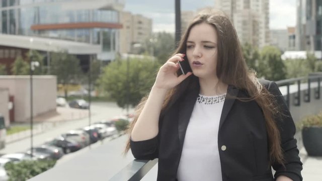 Businesswoman talking phone at handrail