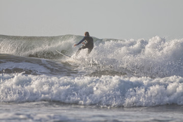 An amateur surfing on the beach.