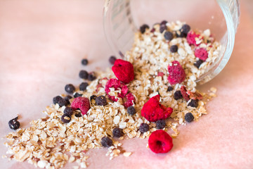 Plate of homemade muesli with cornflakes, freezedried blueberries, freezedried raspberries, linen.
