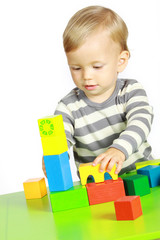 Ein einjähriger Junge spielt mit Holzspielzeug