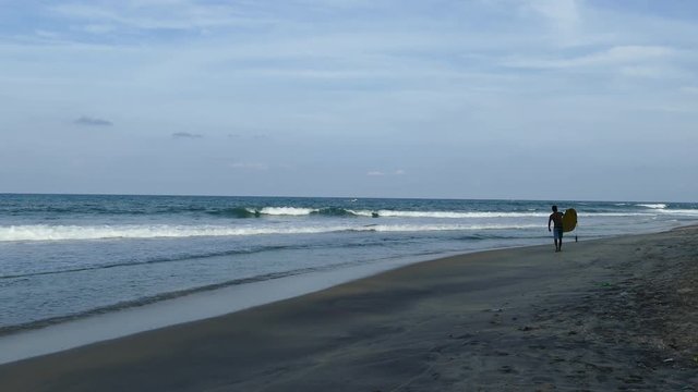 Surfer walks at the beach in Arugam Bay Sri Lanka