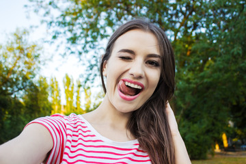 Fototapeta premium beautiful young adult woman taking picture of herself, selfie.