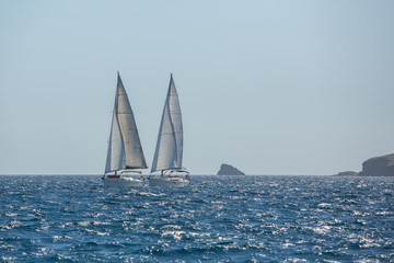 Sailing ship yachts with white sails in the Sea. Luxury boats.