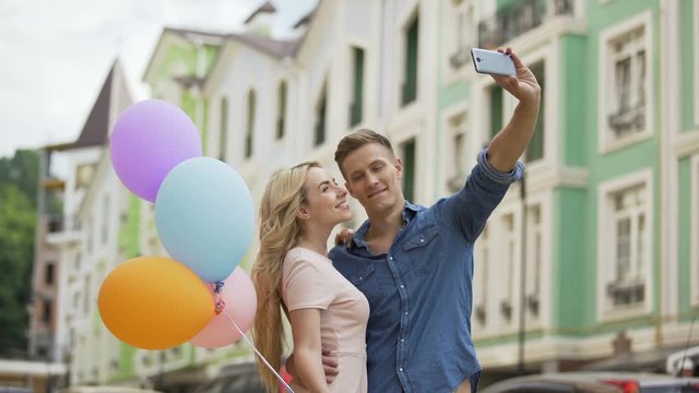Young female and male in love hugging and taking selfie, romantic memories