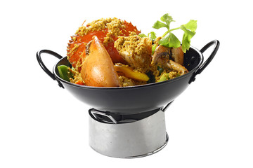 Stir-fried Massive Mud-Crab (Mangrove-Crab or Black-Crab) with Yellow Curry Paste on Black Pan on the Small Oven, Isolated on White Background, High Angle Side Top Side View, Selective Focus at Food.