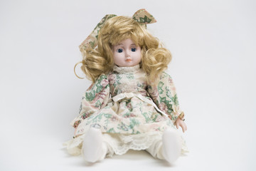 Obraz na płótnie Canvas Ceramic porcelain handmade doll with long blond hair and floral dress