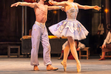 theater, performance, beauty concept. a beautiful couple of ballet dancers in light sky blue costumes showing pas de deux or step of two for world famous production named corsar