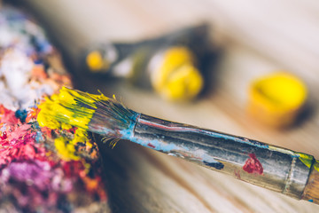 Fototapeta premium Oil paints and paint brushes on a palette close up.