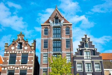 Typical old houses of Amsterdam, Netherlands under blue sky.