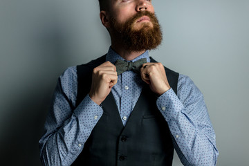 man fixes bow tie he is wearing