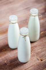 bottles of milk on a wooden rustic table.