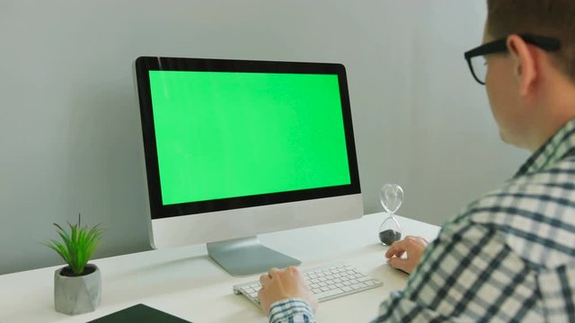 Close up shot of business man in casual shirt using computer with green screen in the modern office. Chroma key.