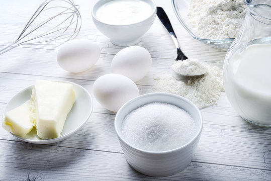 Cooking tools and ingredients on white background. Eggs, butter, sugar, flour, milk