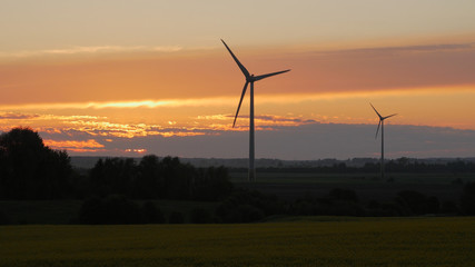 Fototapeta na wymiar Wind turbines farms with rays of light at sunset in the background.
