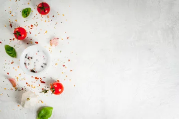 Photo sur Plexiglas Cuisinier Fond de nourriture. Ingrédients, légumes verts et épices pour cuisiner le déjeuner, le déjeuner. Feuilles de basilic frais, tomates, ail, oignons, sel, poivre. Sur une table en pierre blanche. Copier la vue de dessus de l& 39 espace