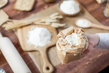Man preparing bread dough on wooden table in a bakery close up
