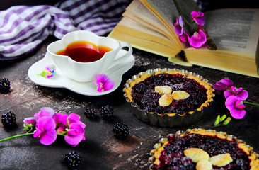 Obraz na płótnie Canvas ежевичный киш с цветами и чашкой чая.завтрак в постель