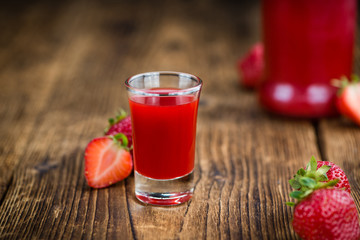 Wooden table with Strawberry liqueur, selective focus