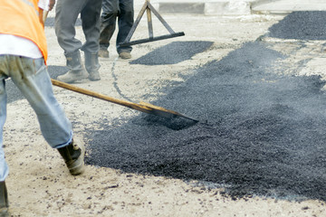 Workers on Asphalting paver machine during Road street repairing works