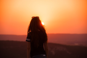 Girl silhouette at sunset against the sun