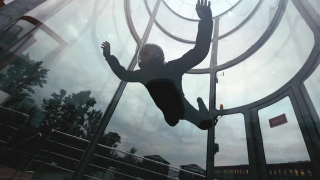 Man skydiver flies in air a wind tunnel slow motion. Extreme parachuting