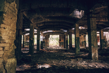 Fototapeta na wymiar Empty ruined hall of abandoned warehouse