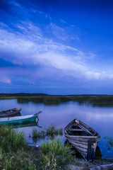 Scenic Destinations. Line of Boats on Water Placed in Belarussian National Park Braslav Lakes at Sunset during Summer Time.