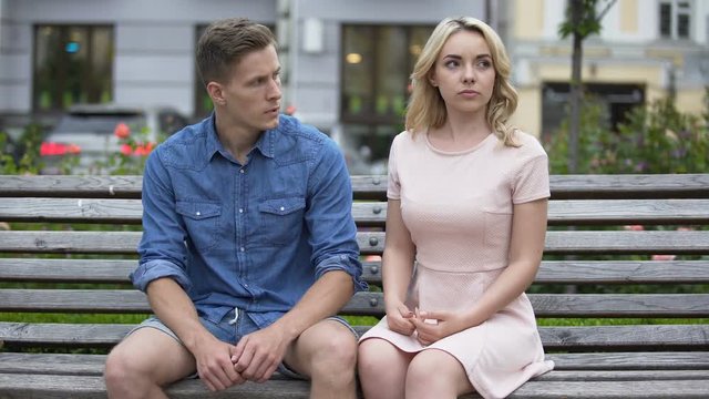 Boyfriend and girlfriend sitting on bench, girl slapping guy on face and leaving