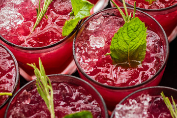 Pink cocktails with mint and rosemary garnishes